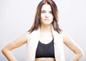 Young woman after training in sport bra with towel