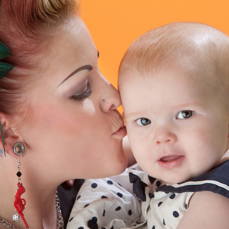 tattooed woman kissing baby