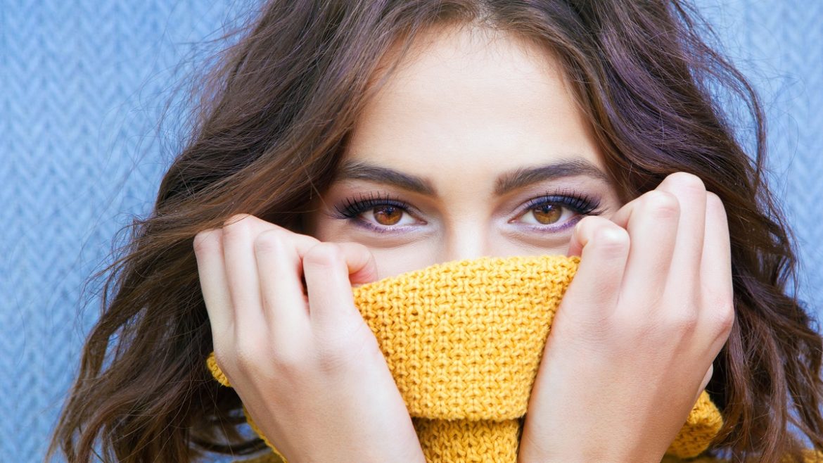 woman hiding nose in sweater