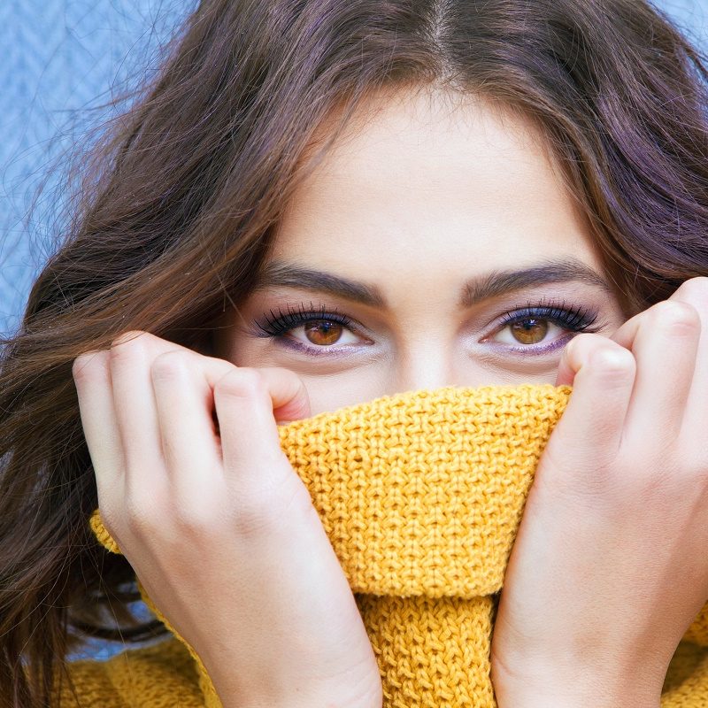 woman hiding nose in sweater