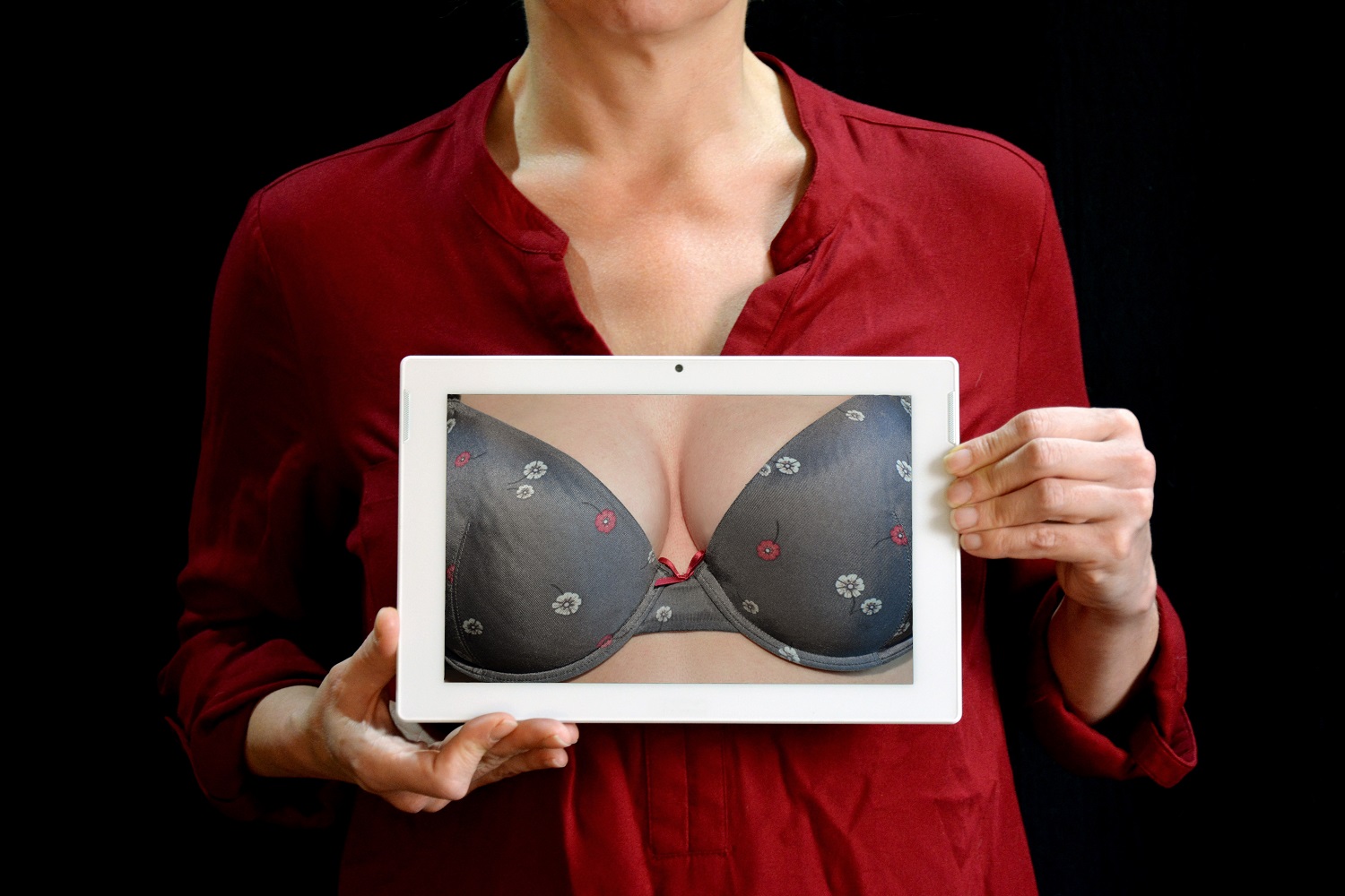 woman holding up photo of breasts