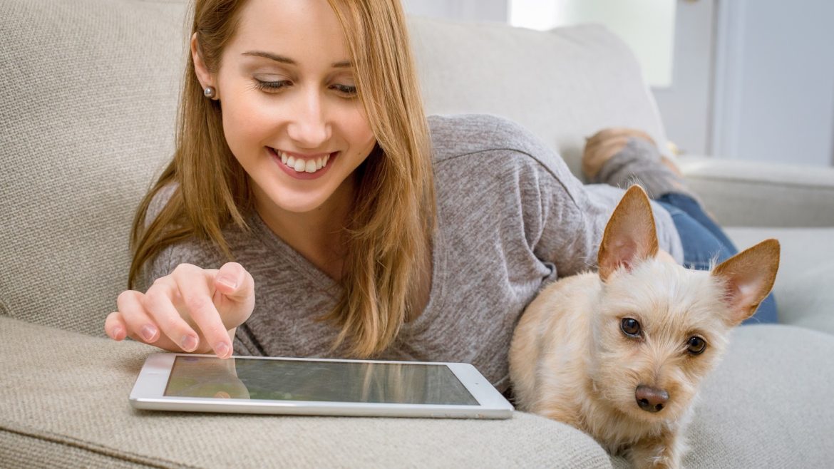 woman with dog and tablet on couch