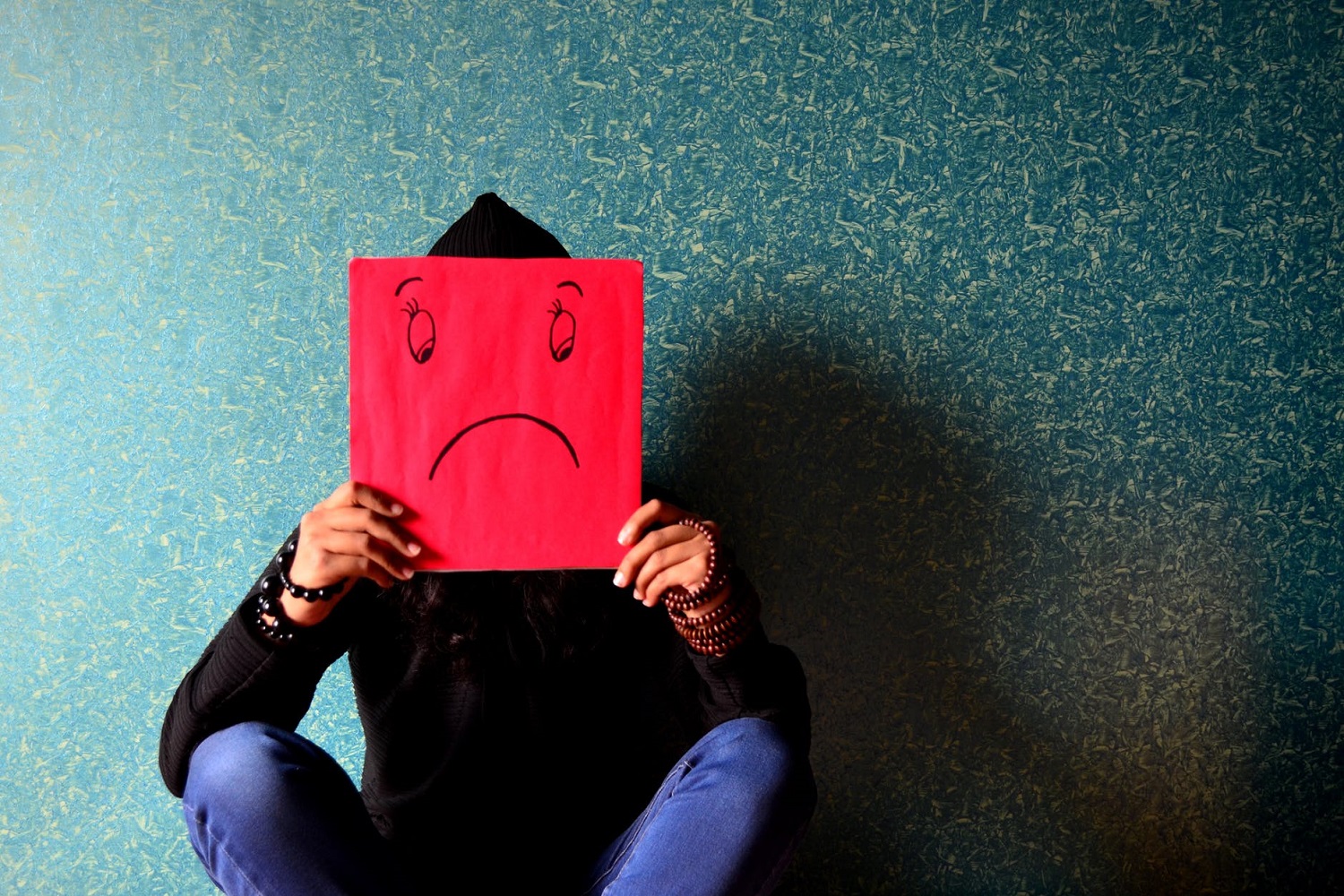 person holding up sad face