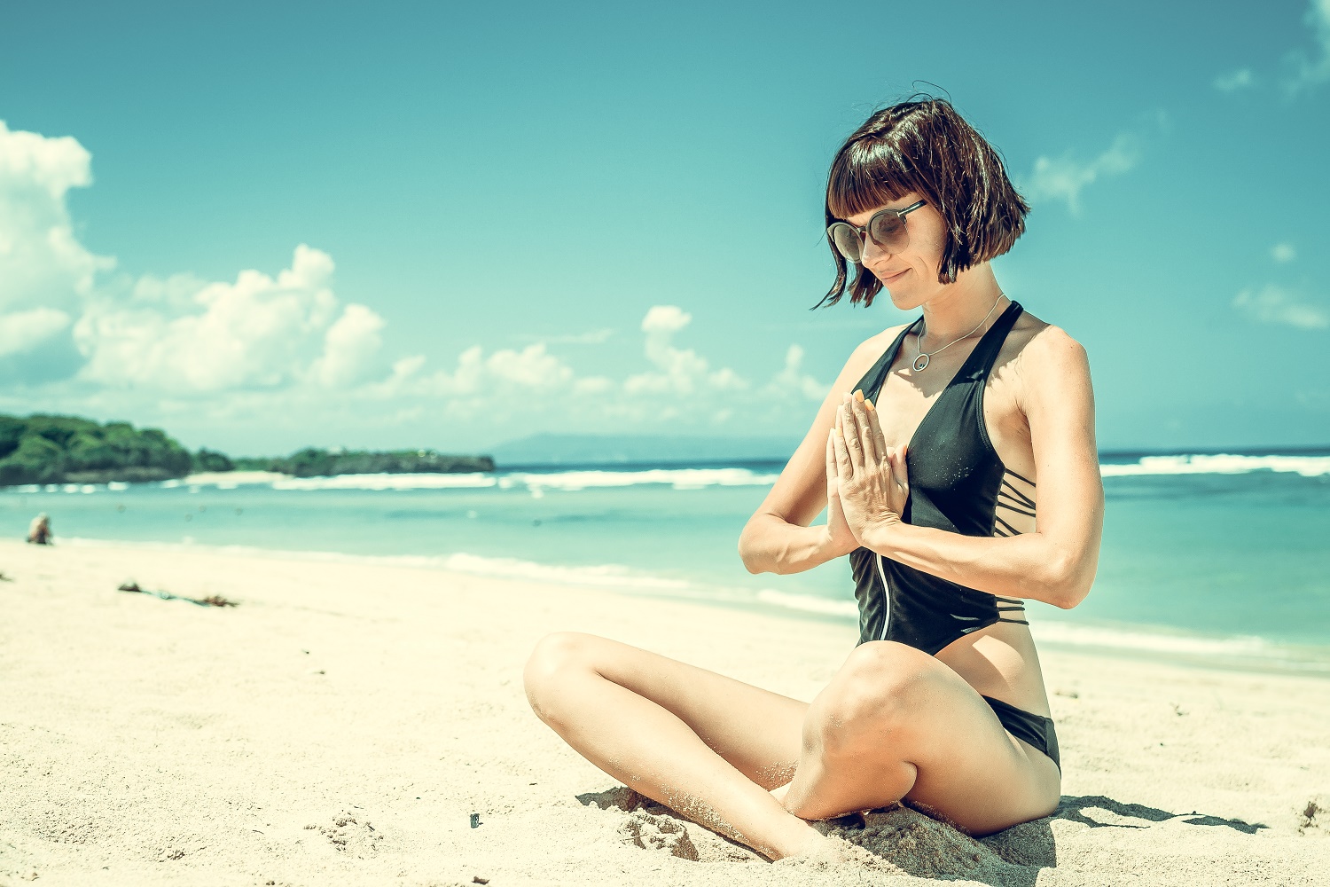 happy woman meditating on beach