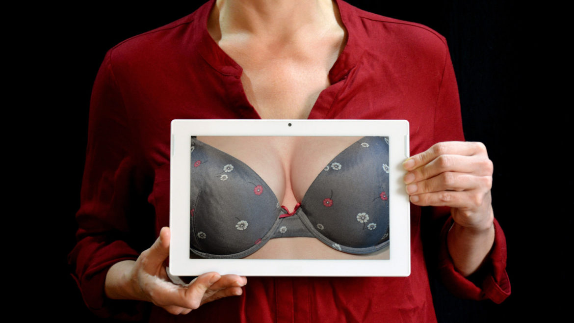 Woman holding up a picture of breasts