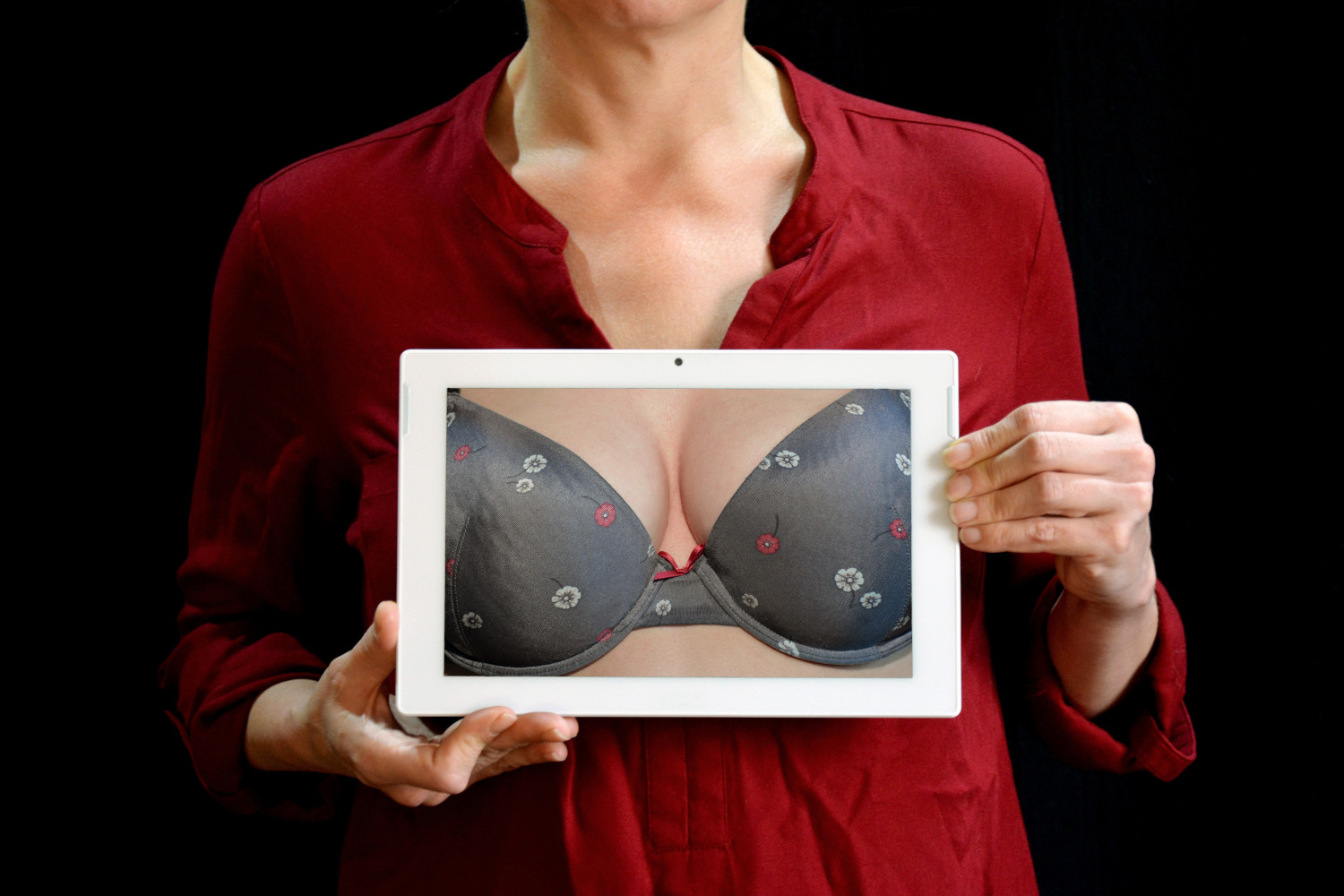 Woman holding up a picture of breasts