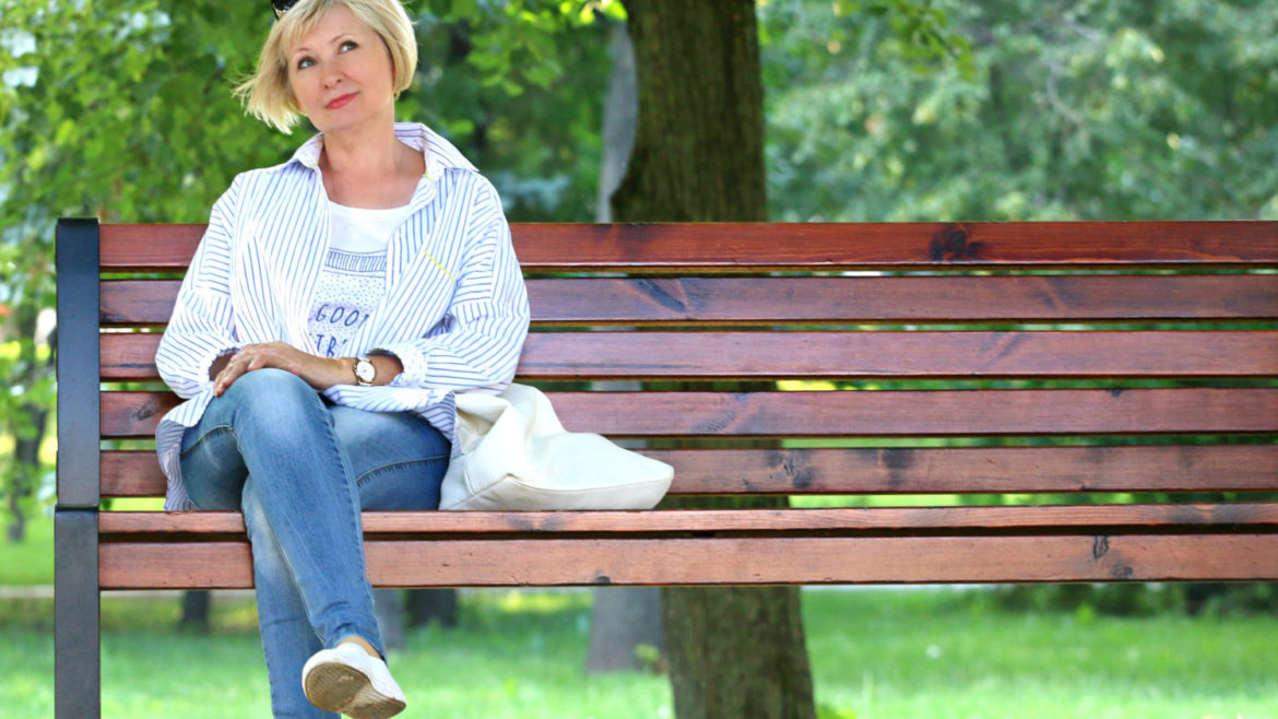 Older woman sitting on a bench.