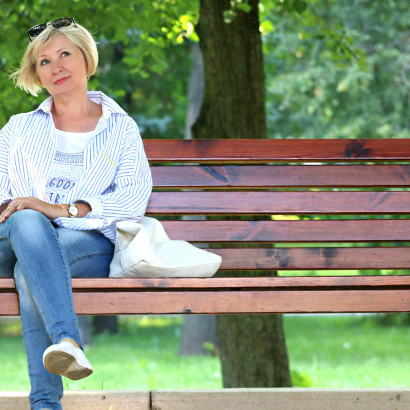 Older woman sitting on a bench.