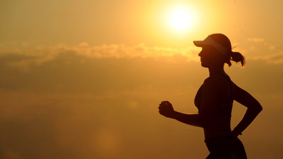 Female runner running during sunset.