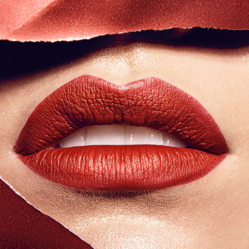 Close up image of a woman's lips with red lipstick.