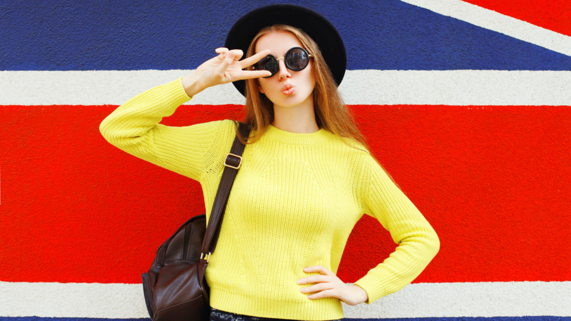 Fashion portrait trendy girl posing in front of a british flag background.