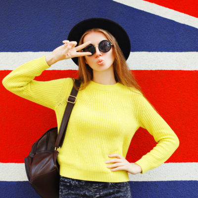 Fashion portrait trendy girl posing in front of a british flag background.