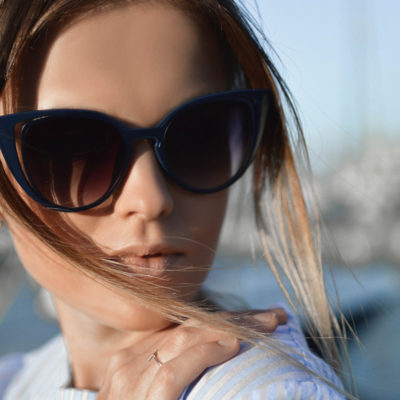Close-up portrait of a female model with smooth skin wearing posh sunglasses.