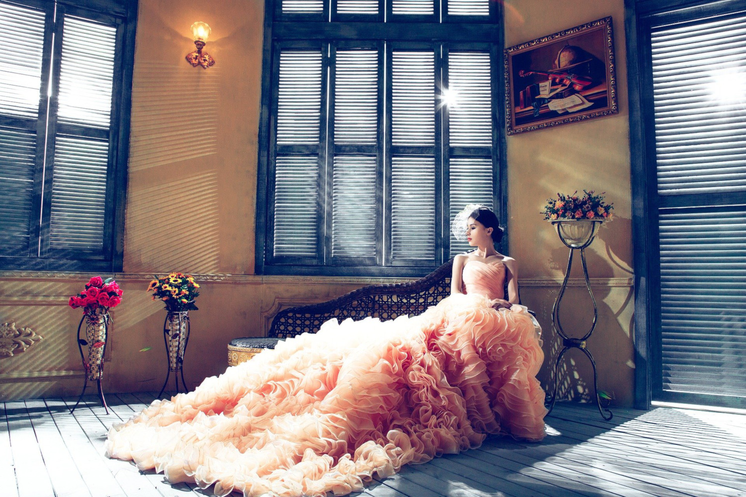 Bride wearing a blush colored wedding dress with a long textured train.
