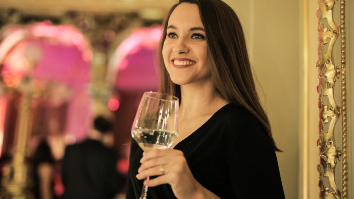 Lovely brunette lady holding a wine glass at a party.