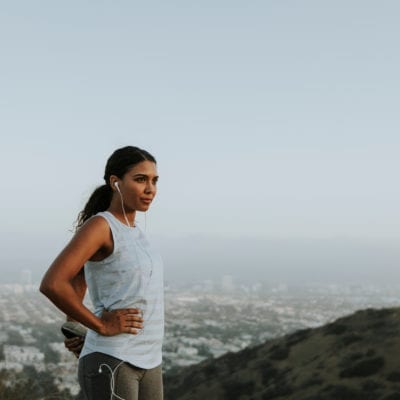 How to prepare for a tummy tuck concept. Woman stretching on a hill before her workout.